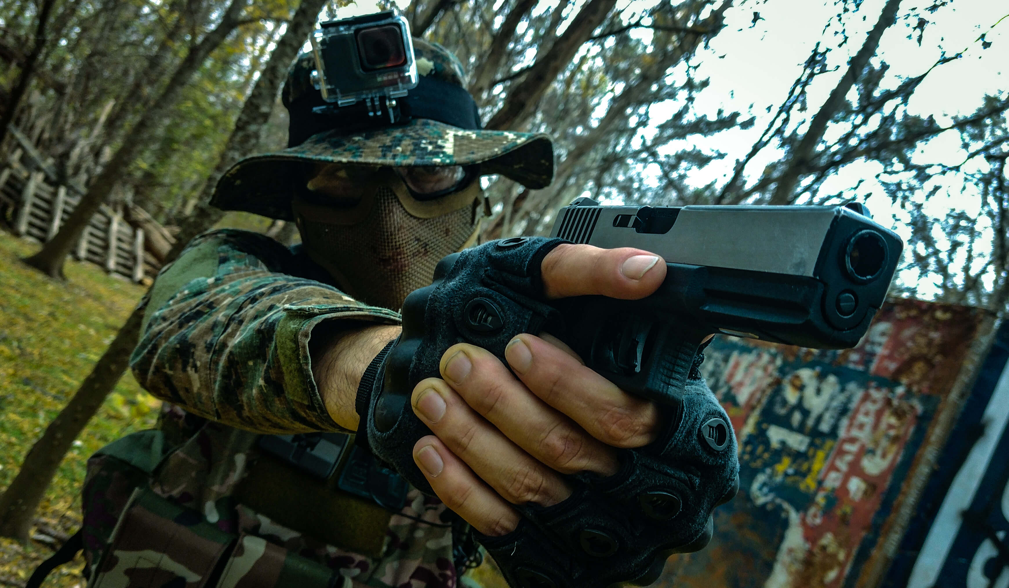 imagen de jugador de airsoft con la pistola y su equipaje posando para la foto